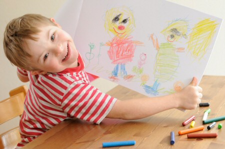 Boy proudly showing the picture he has drawn 