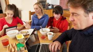 Family using media and technology,eating breakfast