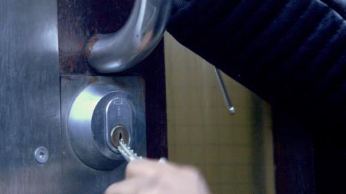 A still from the film of a key in the door