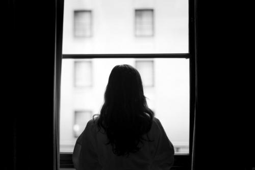 Silhouette of a woman standing at a window